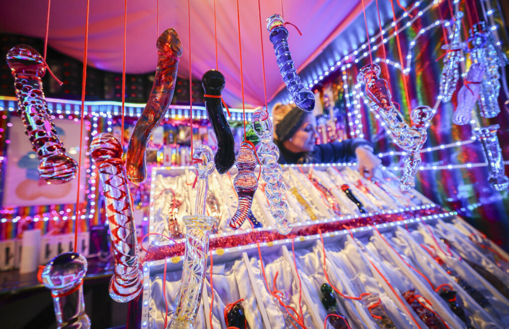 13 November 2023, Hamburg: Glass dildos hang from a stall called "Warm moist and delicious" at the "Santa Pauli" Christmas market on Spielbudenplatz on the opening day. The sinful "Santa Pauli" Christmas market on the Reeperbahn opened on Monday. Photo: Christian Charisius/dpa (Photo by Christian Charisius/picture alliance via Getty Images)